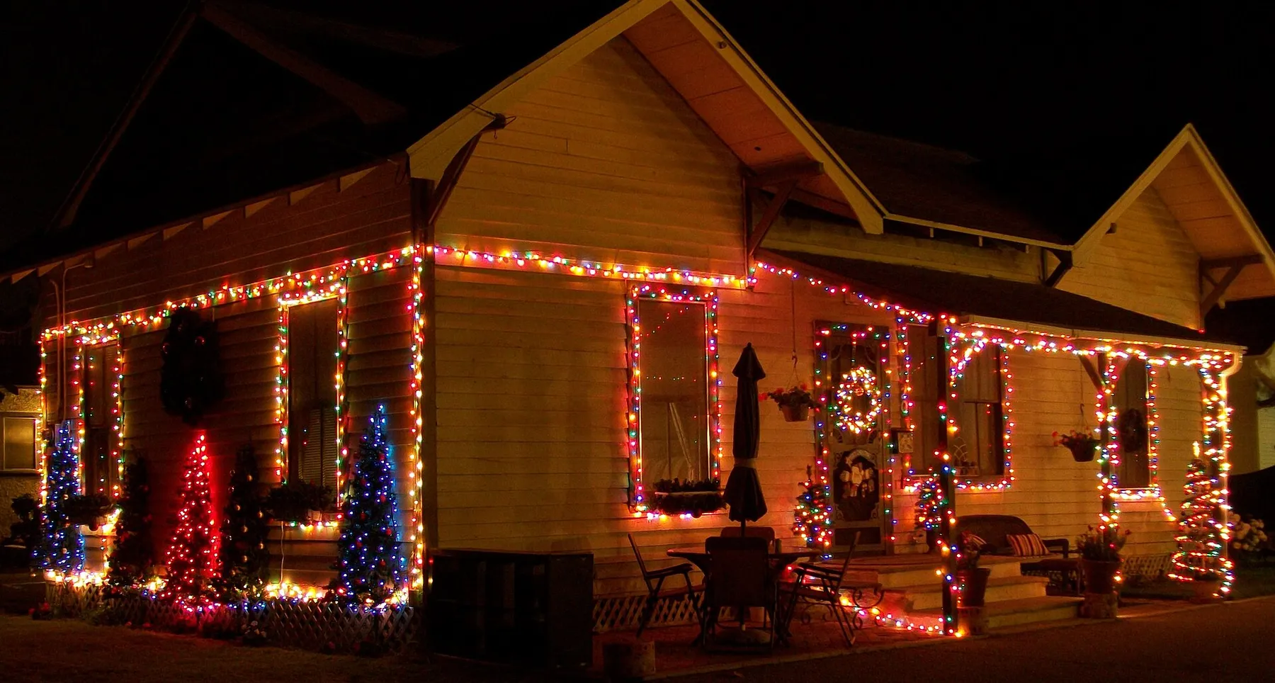 Craftsman bungalow outlined in multicolor C9 Christmas lights