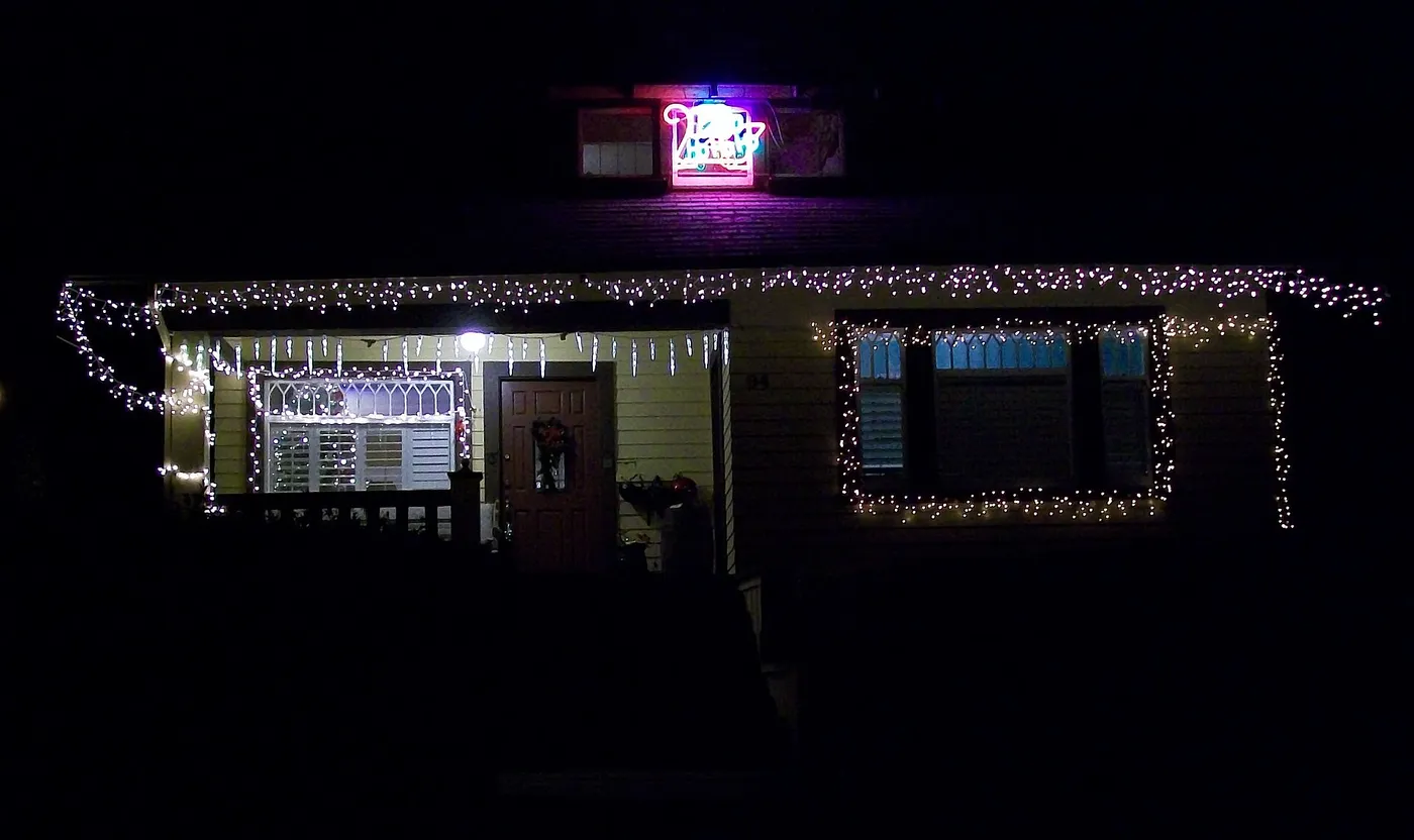 Front porch and roofline lit with white Christmas lights